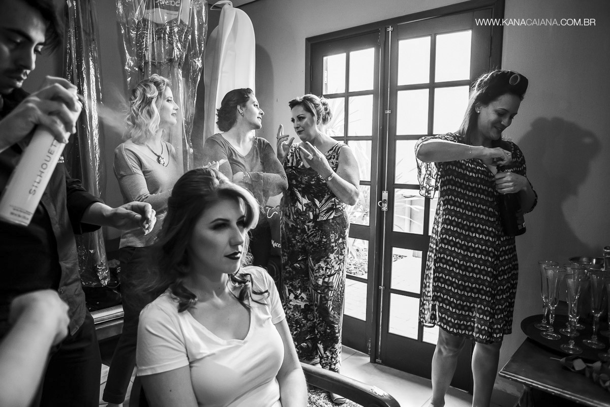 madrinhas se arrumando enquanto noiva abre champagne para o brinde