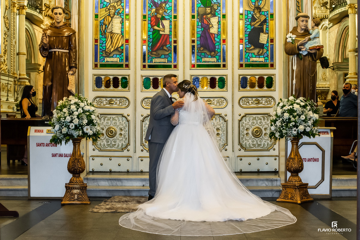 Noiva recebendo um beijo do sue pai na porta da Matriz de Santo Antônio durante casamento em Guaratingueta