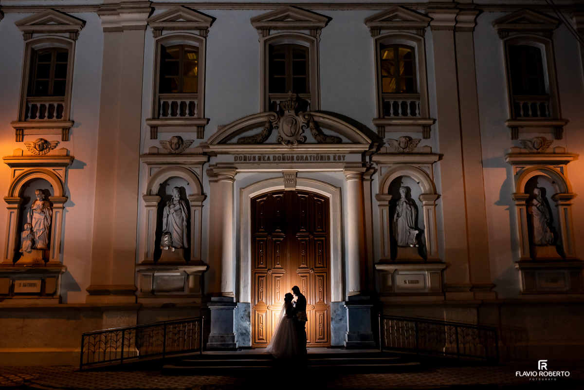 Noivos abraçados em frente da matriz de Santo Antônio em casamento celebrado em Guaratinguetá 