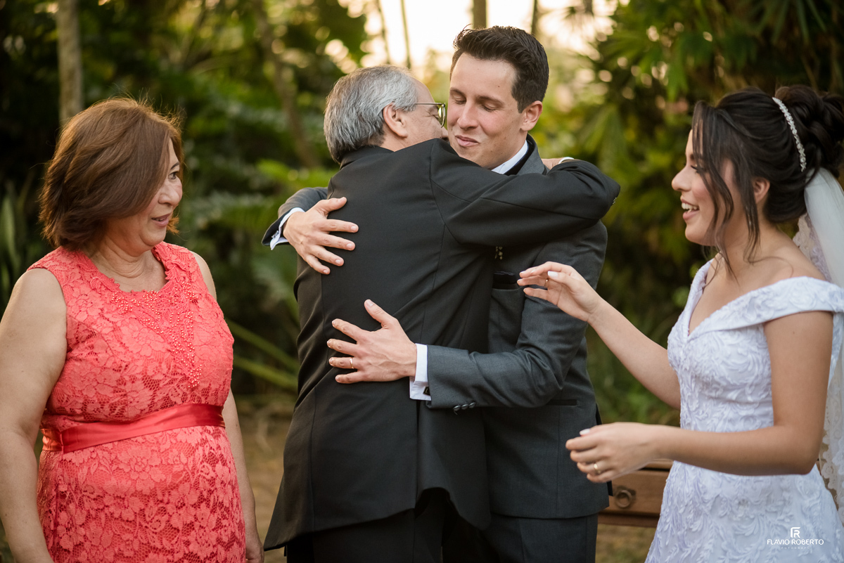 Noivo abraçando seu sogro ao lado de sua noiva e sogra, durante Casamento no Espaço Verde Vale em Taubaté-SP
