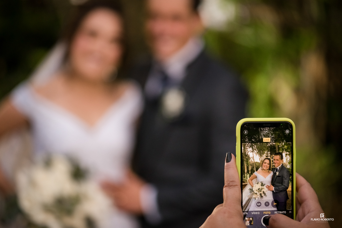 Convidado fotografando os noivos com celular Noivos durante Casamento no Espaço Verde Vale em Taubaté