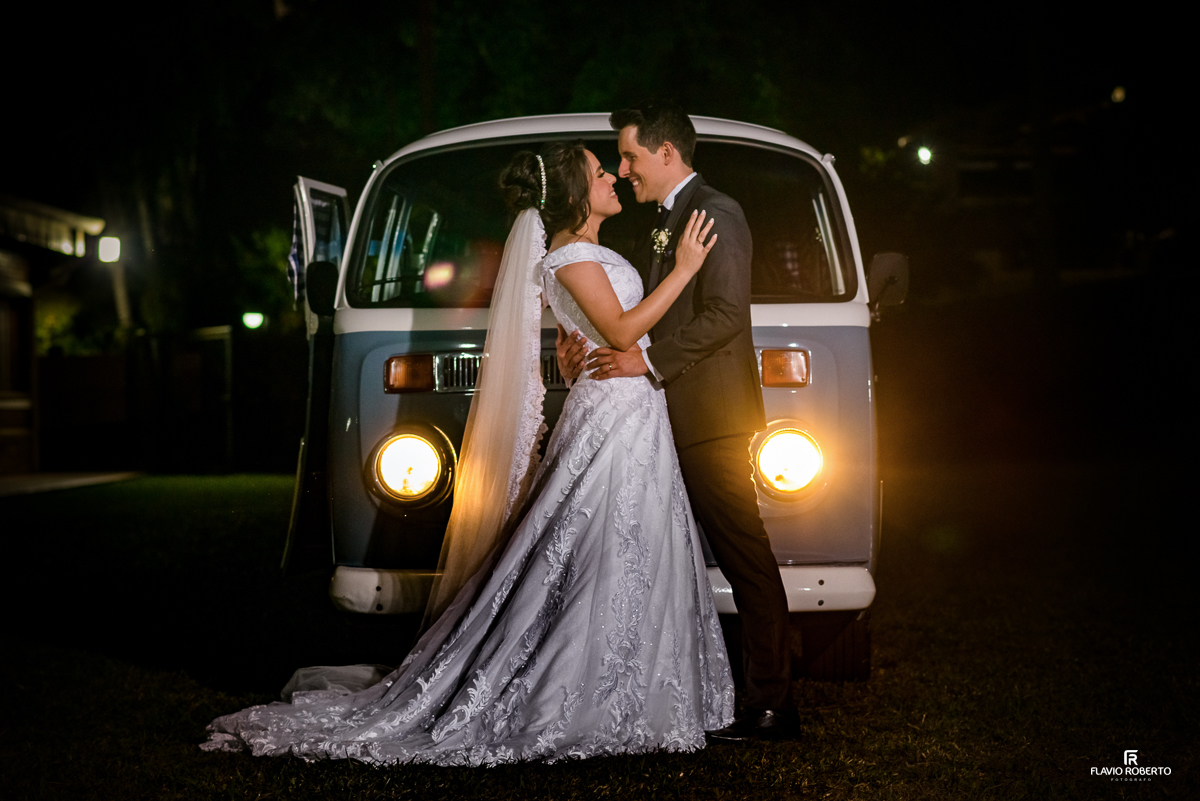 Noivos abraçados na frente da Kombi durante Casamento no Espaço Verde Vale em Taubaté