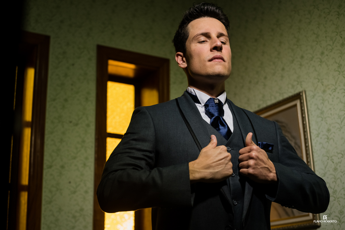 Noivo colocando seu terno em Casamento no Espaço Verde Vale em Taubaté-SP