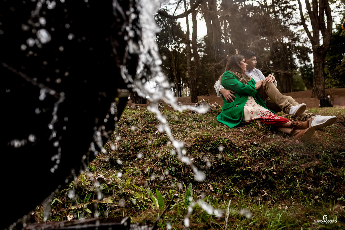 noivos sentados do lado da água durante Ensaio Pre Wedding no Horto de Florestal de Campos de Jordão