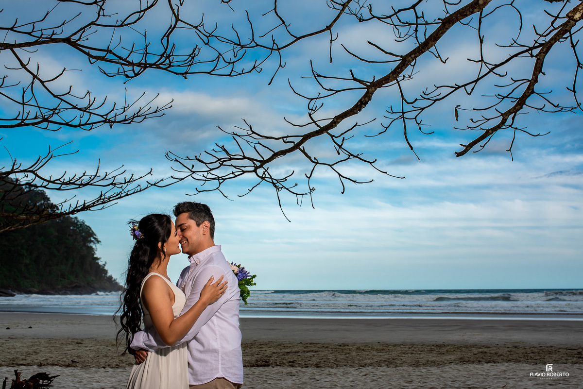 casal abraçado em baixo de uma árvore de galhos secos durante Ensaio Pre Wedding na Praia Itamambuca de Ubatuba