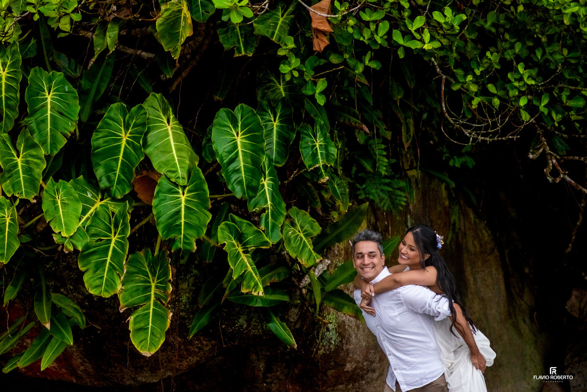 noivo levando sua noiva de cavalinho nas costas durante Ensaio Pre Wedding na Praia Itamambuca de Ubatuba