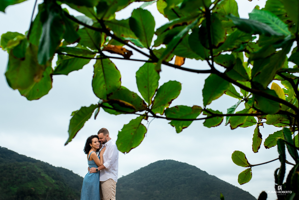 casal abraçado aos pés da montanha, durante Ensaio Pre Wedding na praia vermelha do norte em ubatuba