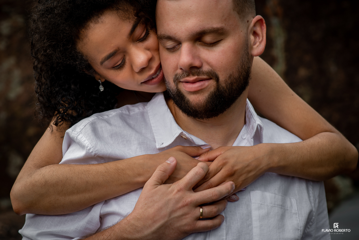 noivos abraçados namorando nas pedras, durante Ensaio Pre Wedding na praia vermelha do norte em ubatuba