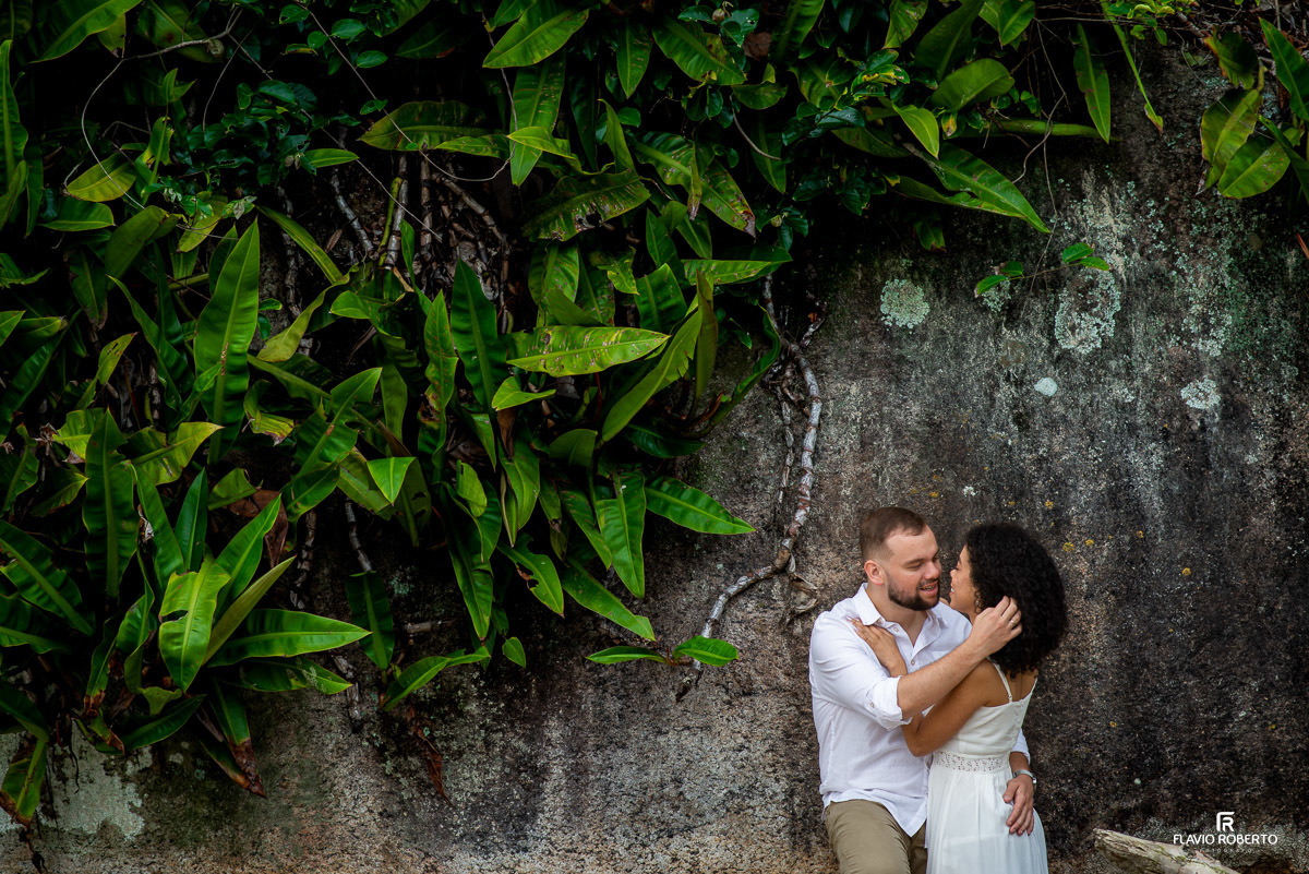casal entre as árvores nas rochas durante Ensaio Pre Wedding na praia vermelha do norte em ubatuba