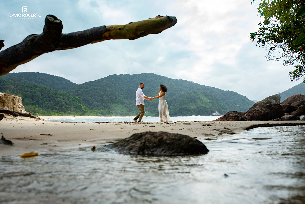 noivos brincando de mãos dadas durante Ensaio Pre Wedding na praia vermelha do norte em ubatuba