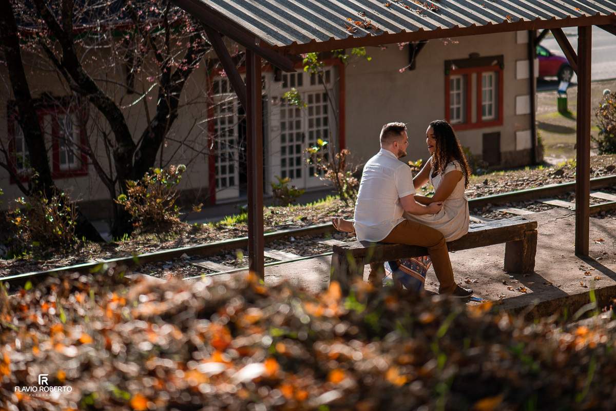 casal sentado na estação de trem durante Ensaio Pre Wedding em Campos do Jordão