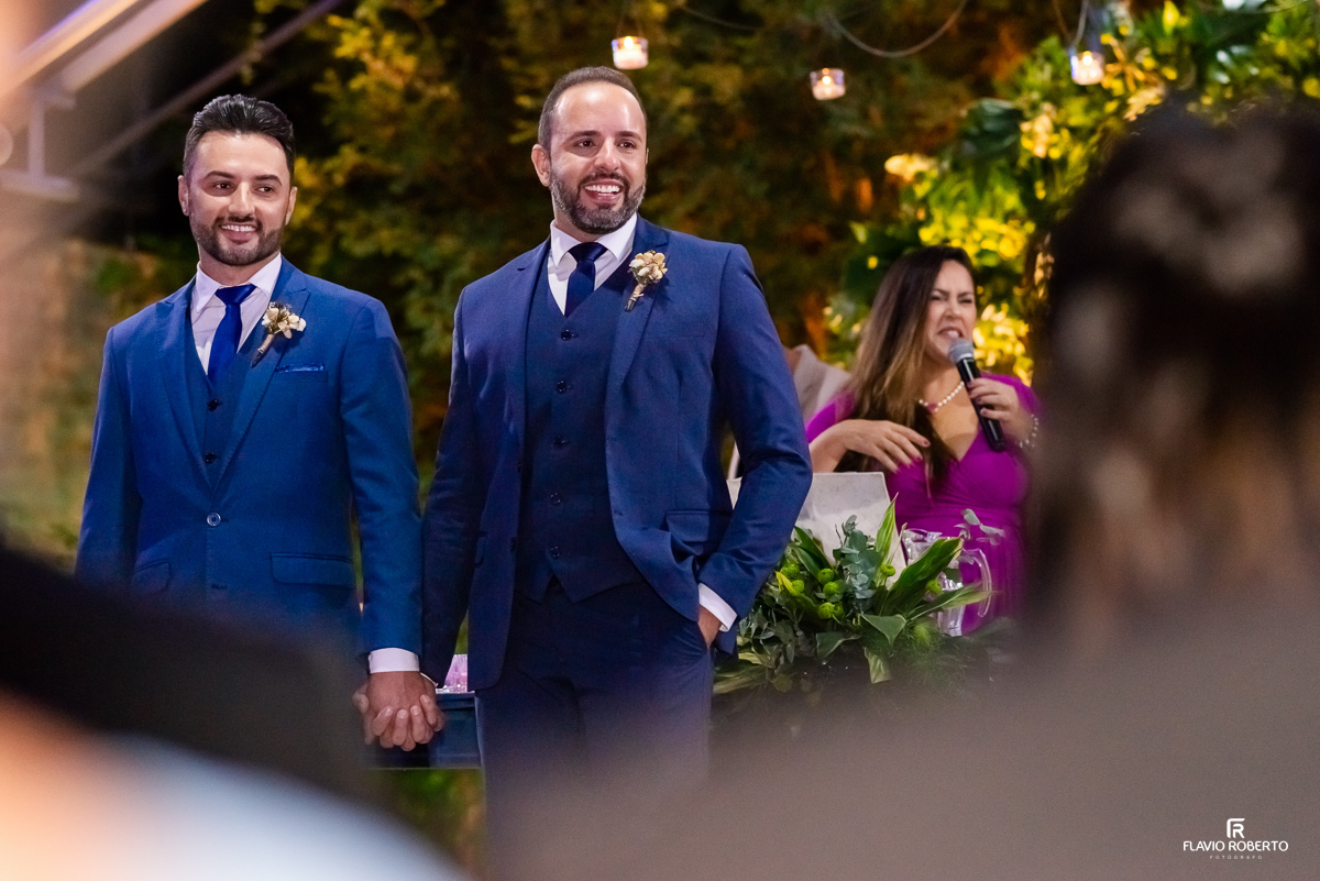  Noivos olhando seus convidados durante o Casamento na capela do Amadeus Cristal Palace em Taubaté.