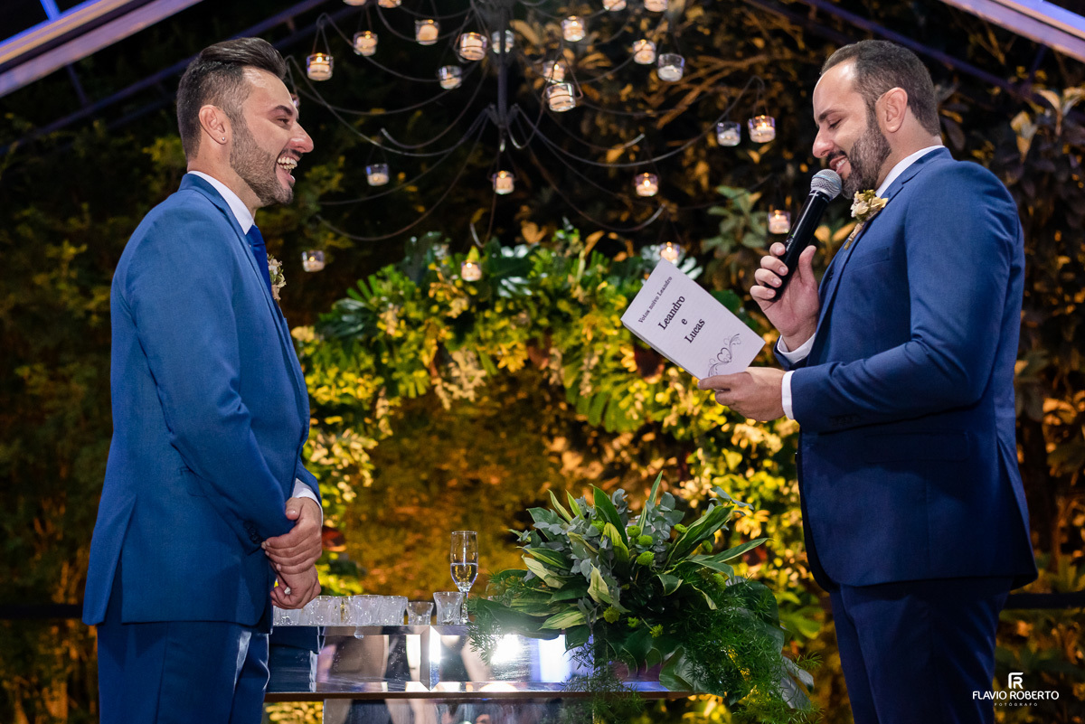 Casal de noivos rindo durante os votos durante cerimonia da areia na capela do Amadeus Cristal Palace em Taubaté.