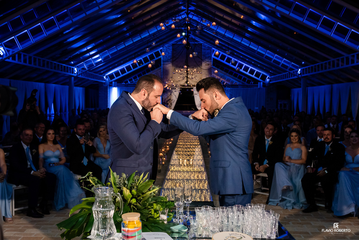 Noivos beijando suas mãos durante Cerimônia de Casamento no Amadeus Cristal Palace em Taubaté. 