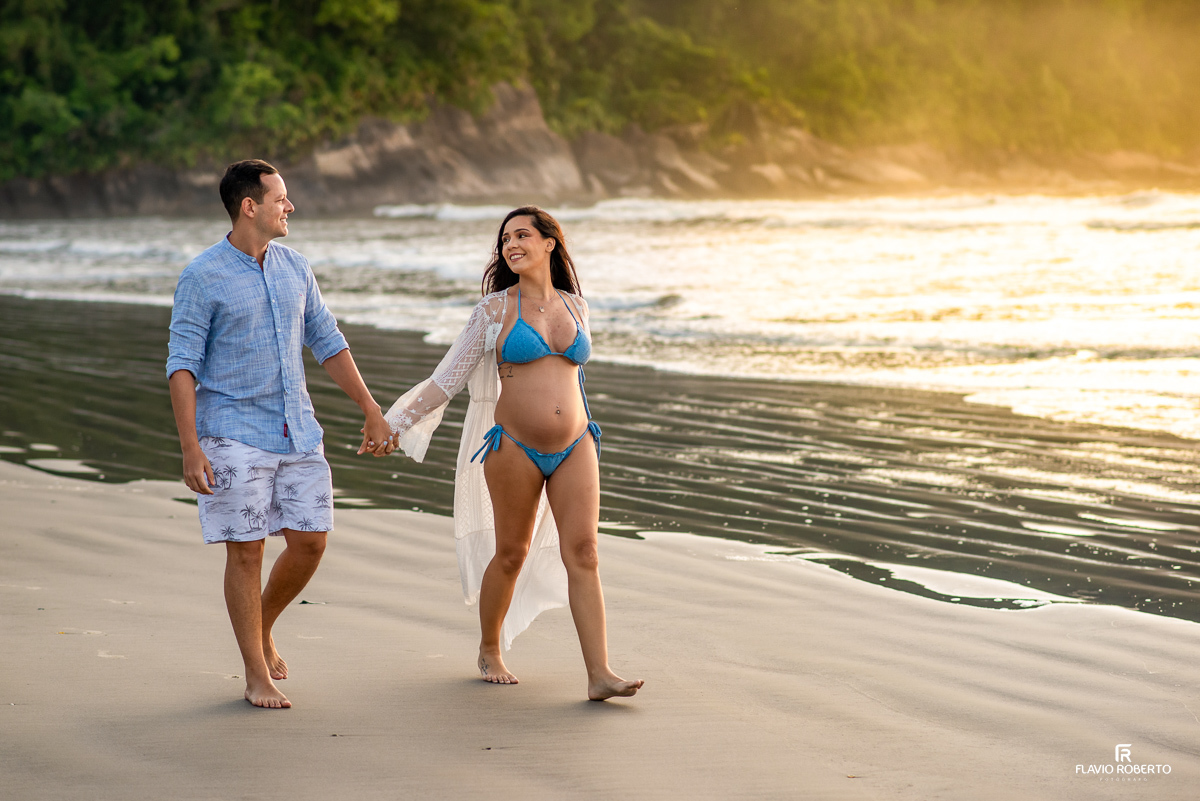 casal gestante caminhando pela praia de Itamambuca em Ubatuba durante ensaio de gestante