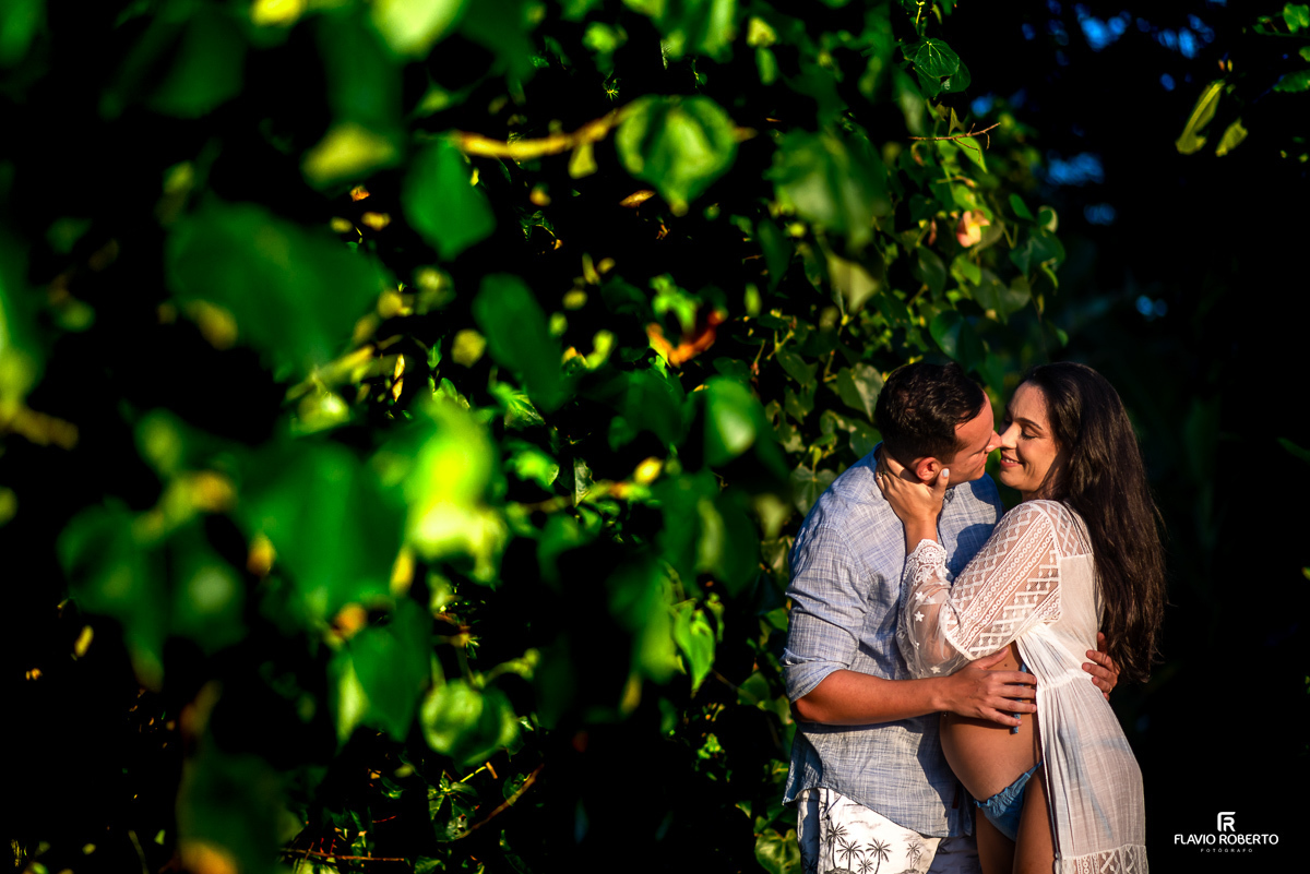 casal gestante abraçado na praia de Itamambuca em Ubatuba durante ensaio de gestante