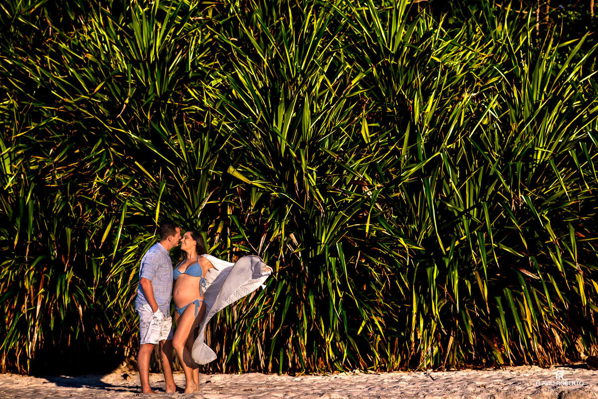 casal gestante abraçado conversando na praia de Itamambuca em Ubatuba durante ensaio de gestante