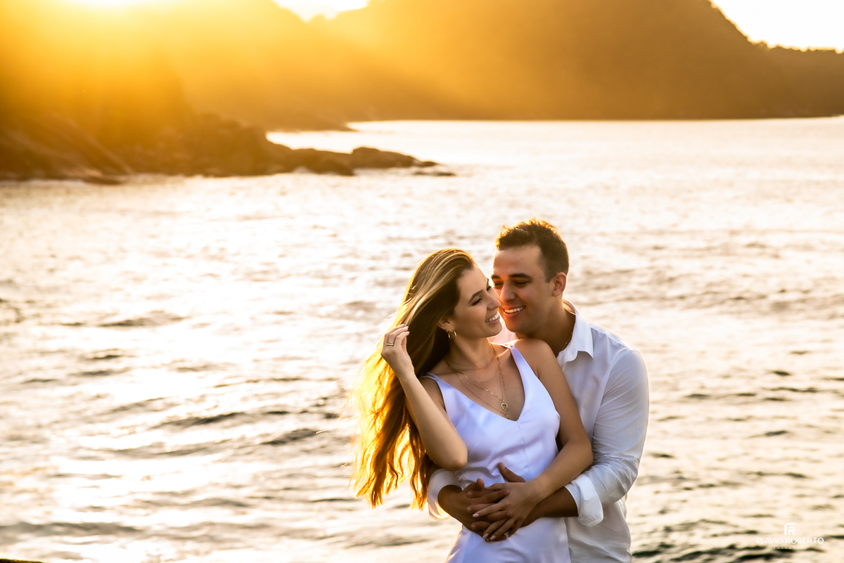 casal abraçado durante nascer do sol na praia em pre wedding no Rio de Janeiro