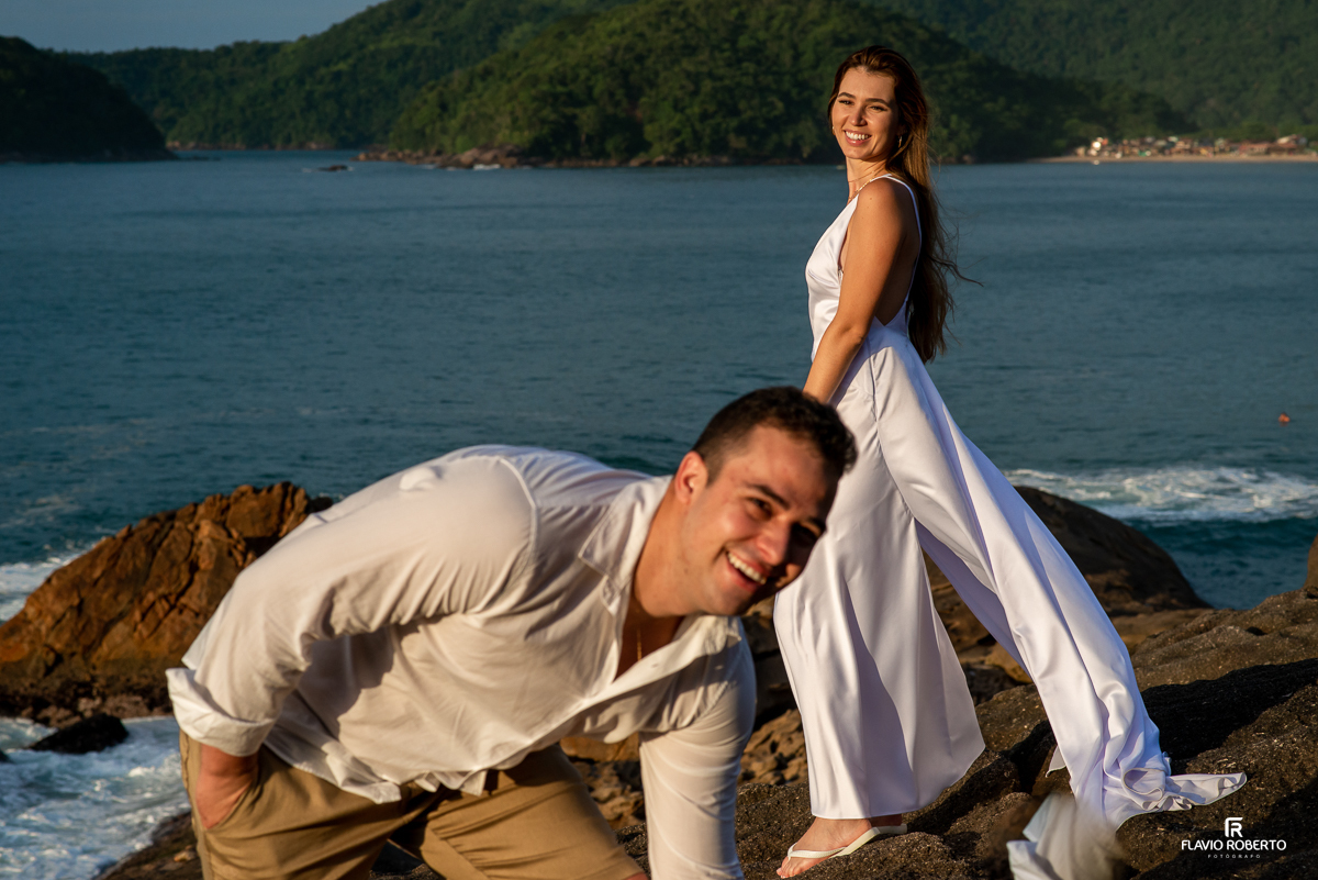 casal sorrindo nas rochas da praia no pre wedding no Rio de Janeiro