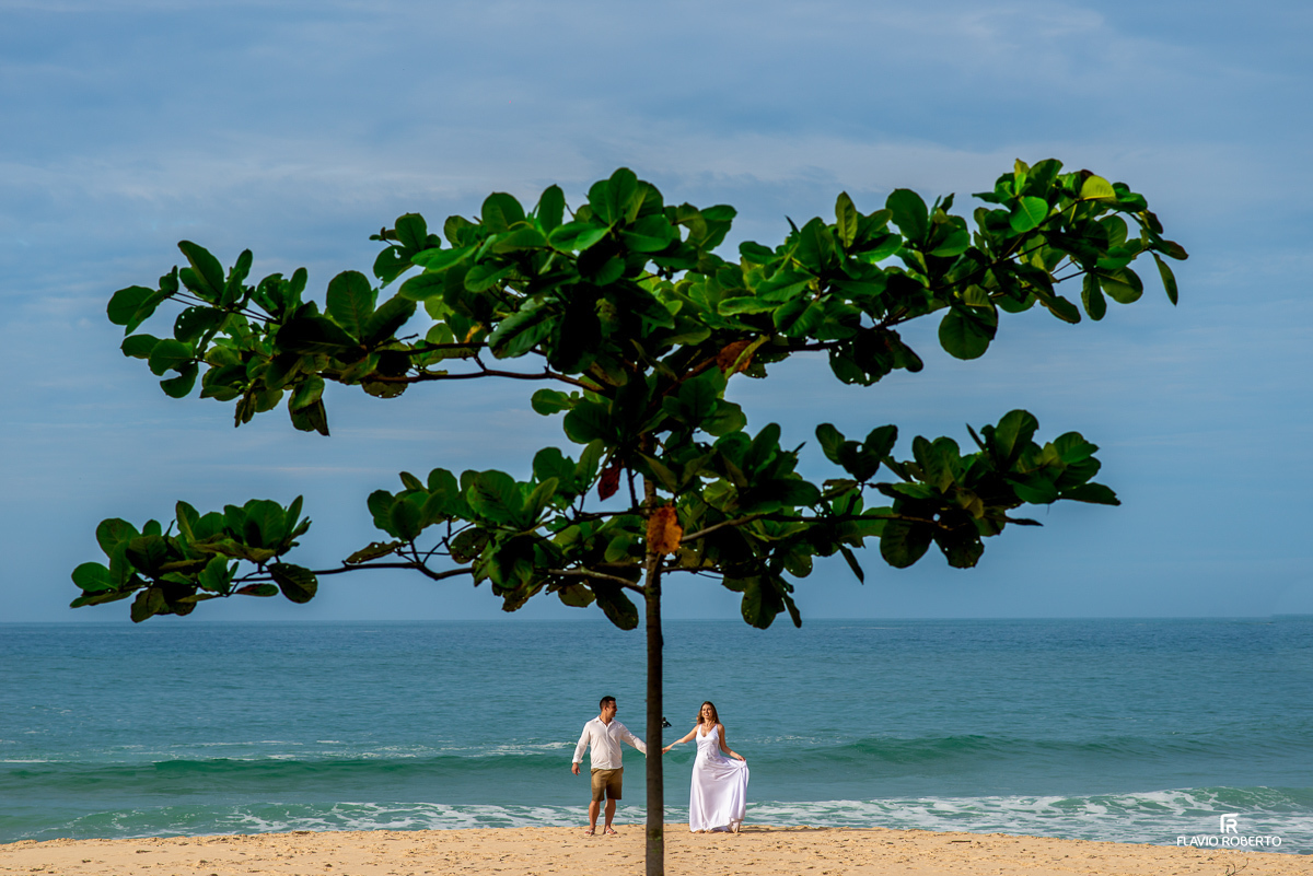 casal de mãos dadas em baixo de uma árvores na praia no pre wedding no Rio de Janeiro