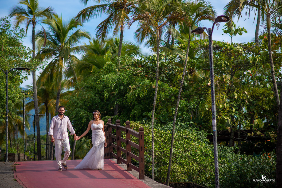 casal caminhando de mãos dadas por uma passarela durante ensaio pre wedding em Ilhabela