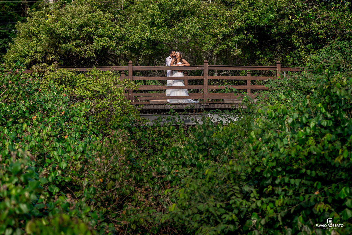 Casal abraçado em uma ponte sobre várias árvores, durante ensaio pre wedding em Ilhabela