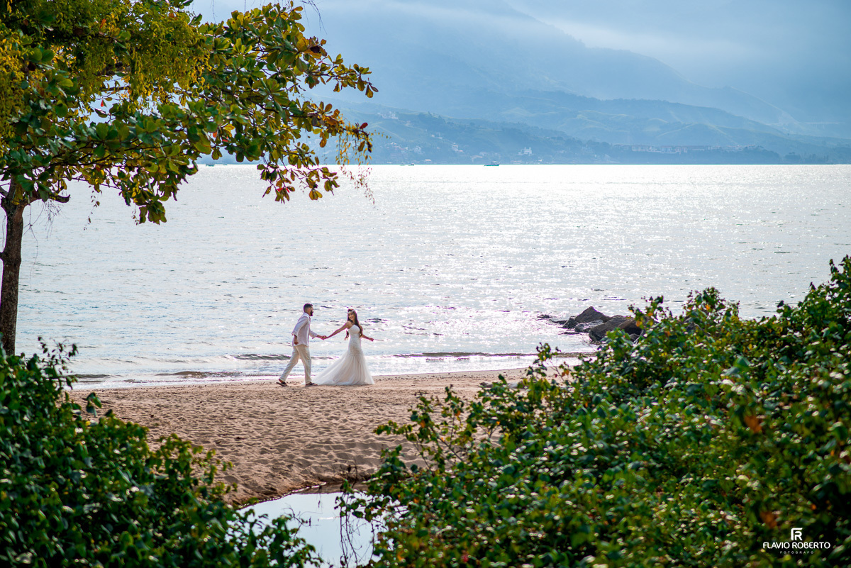 noivos caminhando na praia durante ensaio pre wedding em Ilhabela
