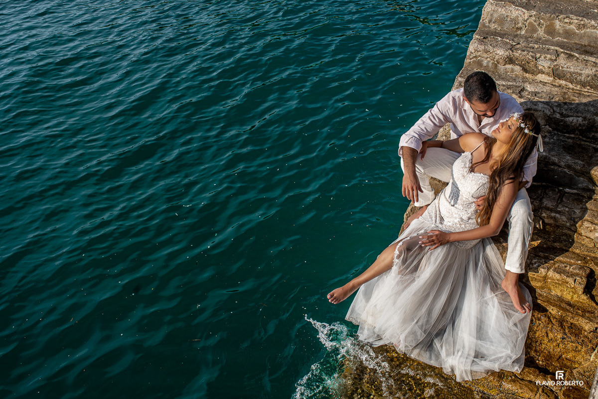 casal deitado em uma escada do lado do mar, durante ensaio pre wedding em Ilhabela