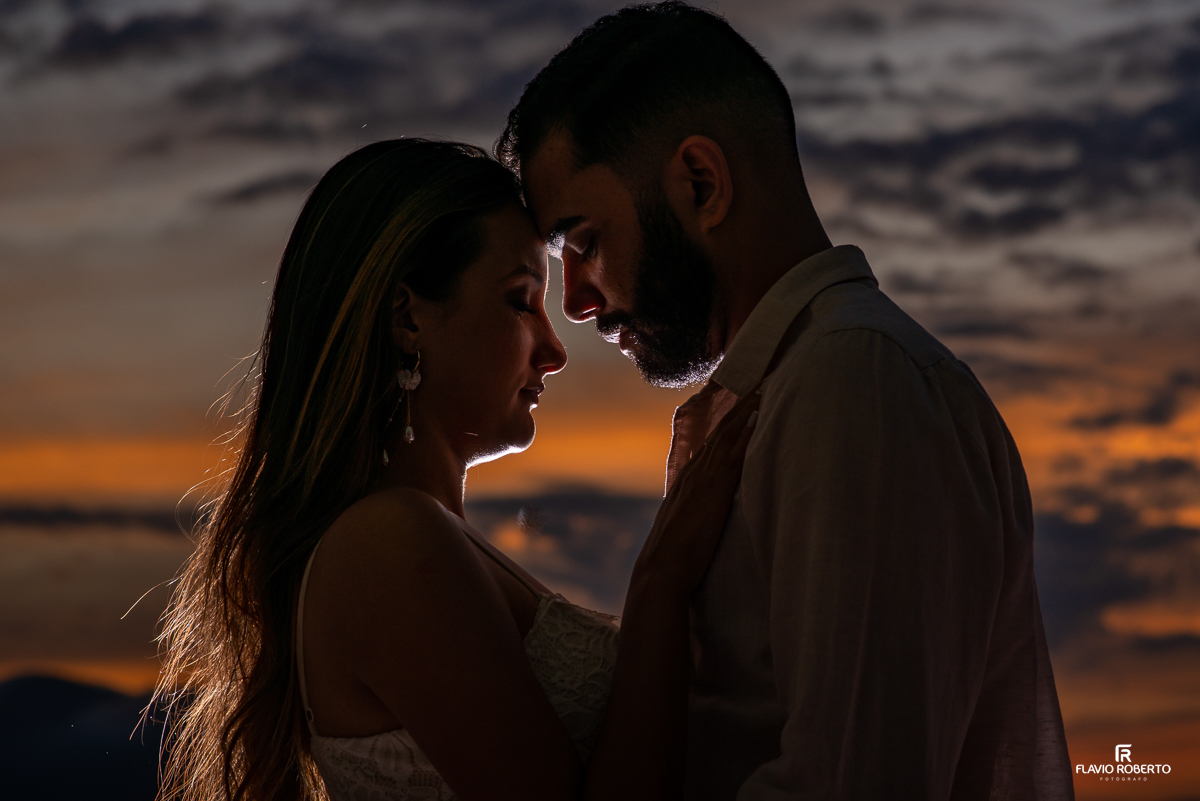 silhueta do casal de cabeças juntas durante lindo entardecer, durante ensaio pre wedding em Ilhabela