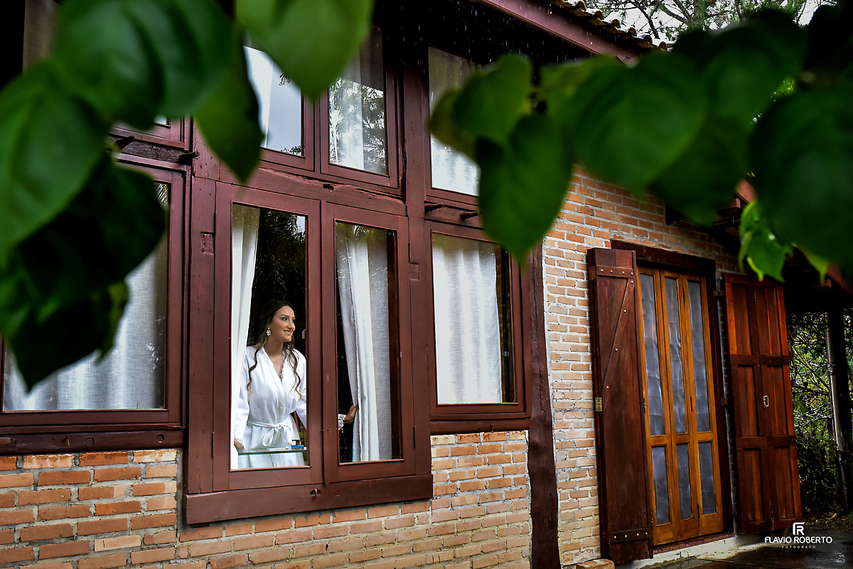 Noiva olhando pela janela na casa da noiva no Casamento no Rancho Mustang em Pindamonhangaba.