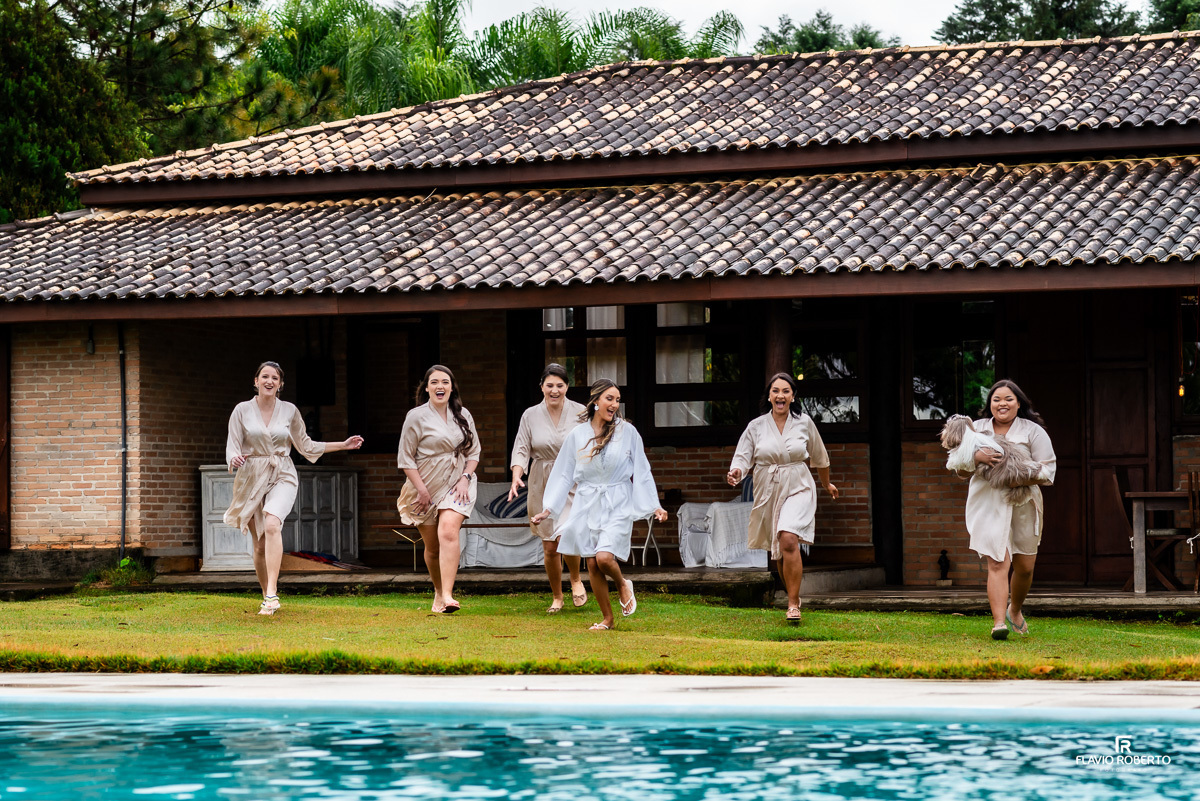 Noiva correndo com suas madrinhas na casa da noiva durante Casamento no Rancho Mustang em Pindamonhangaba.