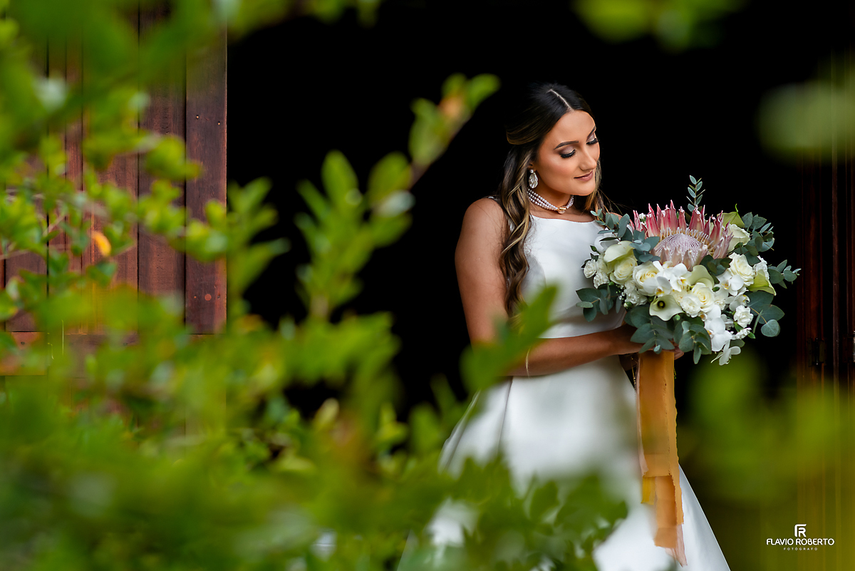 Noiva olhando seu buquê antes do início do Casamento no Rancho Mustang em Pindamonhangaba.
