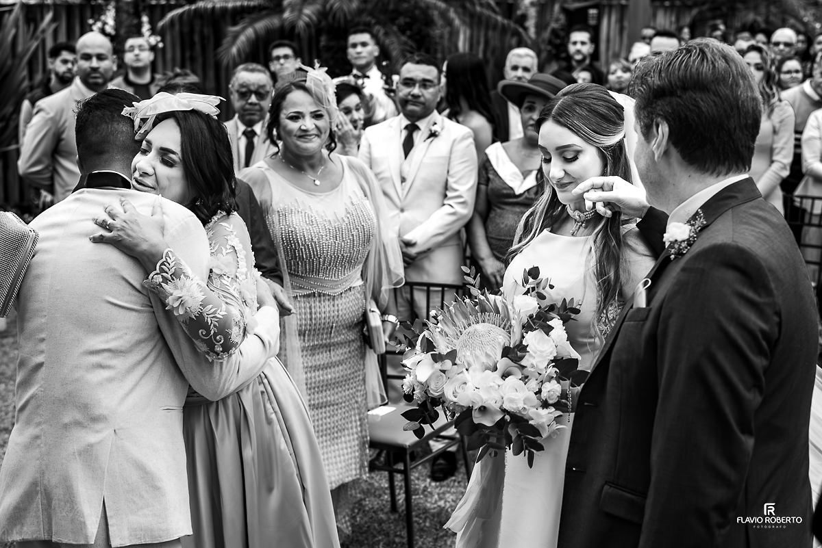Noica chorando sendo consolada pelo pai, enquanto noivo é abraçado pela sogra, durante Casamento no Rancho Mustang em Pindamonhangaba.