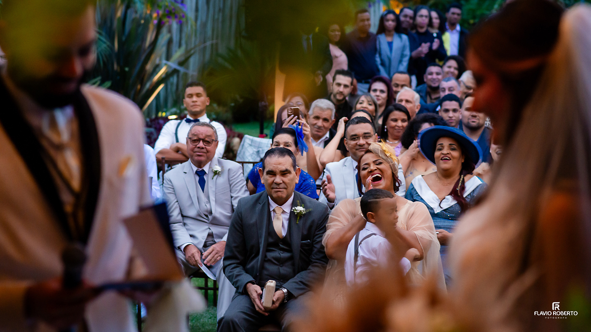 Pais do noivo rindo durante votos dos noivos durante Casamento no Rancho Mustang em 