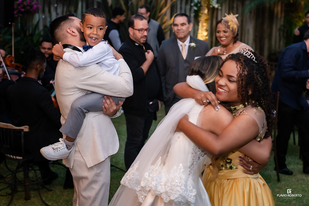 damas de honra e pagem abraçando noivos no Casamento no Rancho Mustang em Pindamonhangaba.