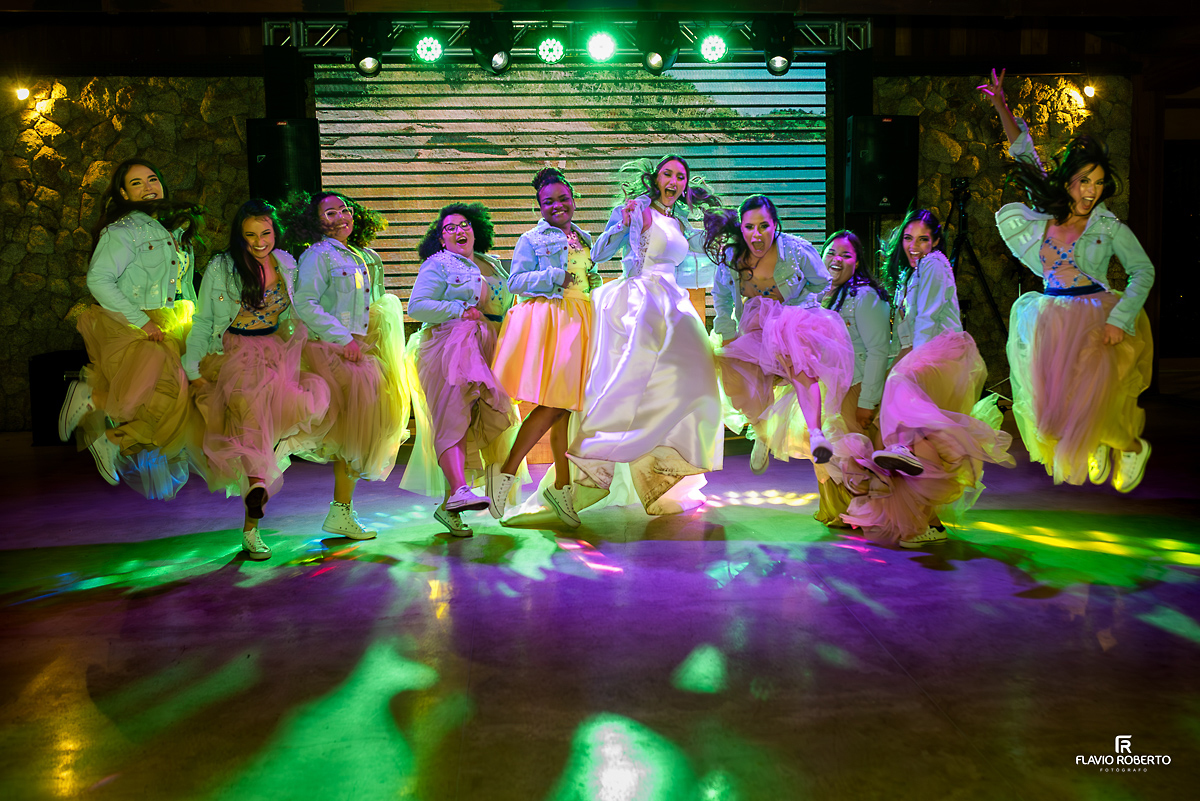 Noiva com suas madrinhas saltando de jaqueta jeans no Casamento no Rancho Mustang em Pindamonhangaba.
