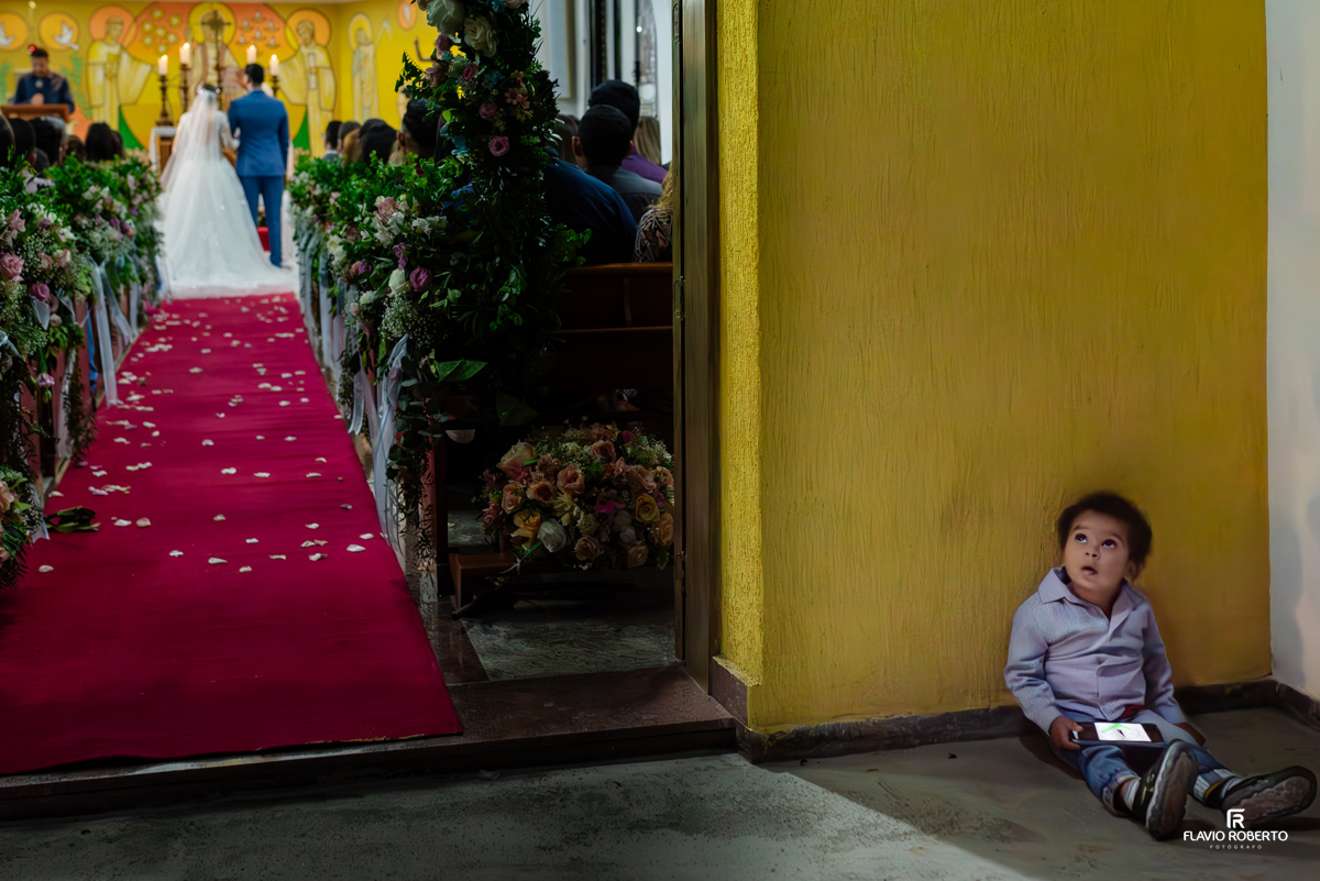 criança sentada na porta da igreja durante casamento na Igreja de São João Batista em Itapecerica da Serra