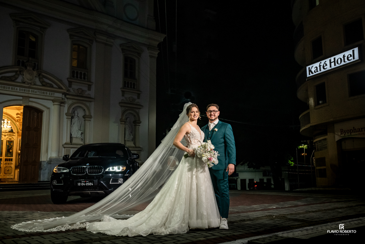 Noivos abraçados durante o ensaio de fotos em frente da Matriz de Santo Antônio em Casamento realizado em Guaratinguetá 
