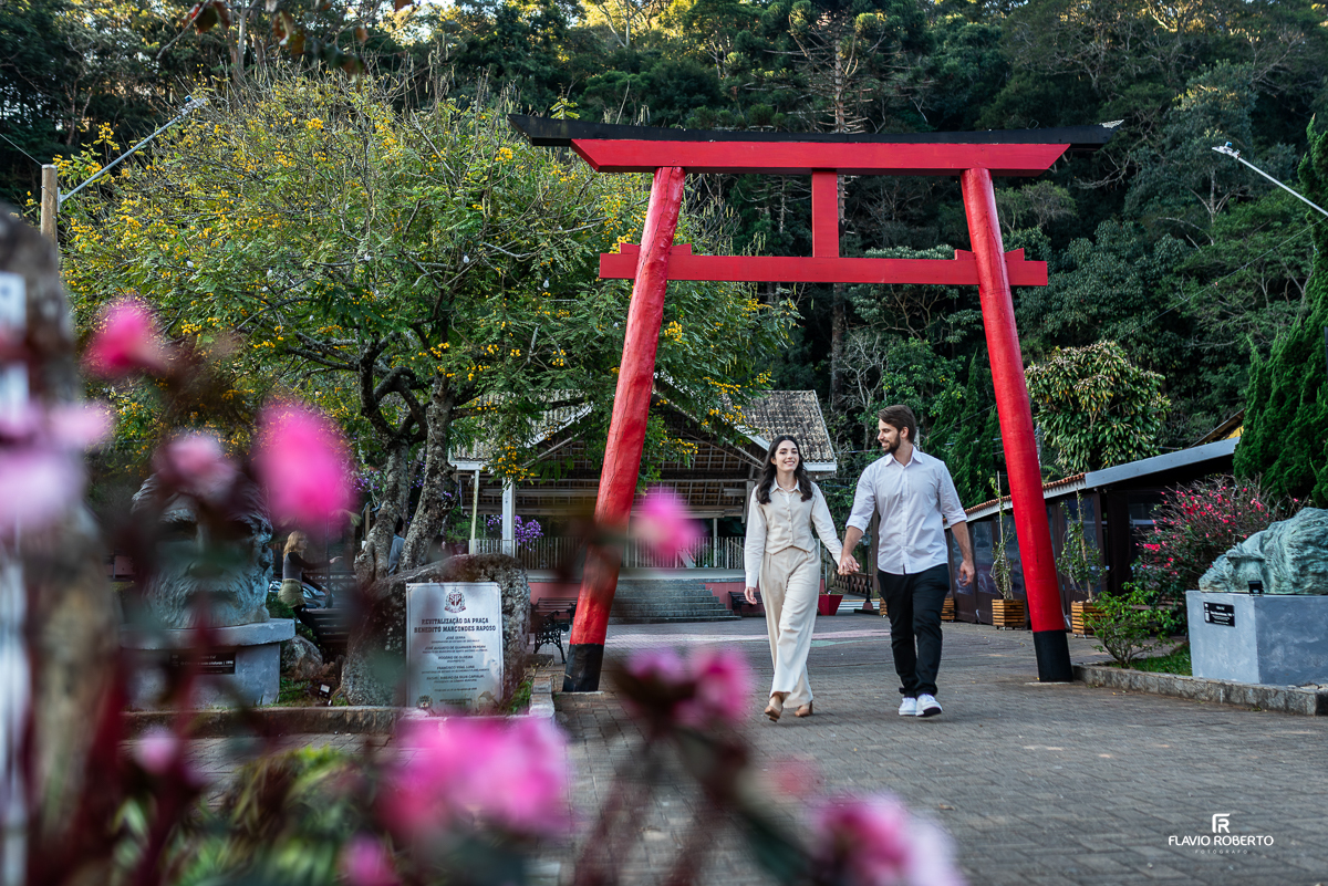 Casal caminhando de mãos dadas na praça em Santo Antônio do Pinhal.