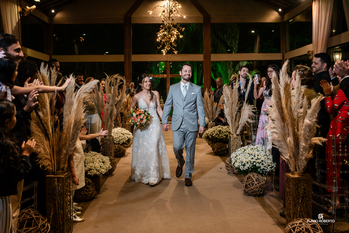 Laís e Alessandro celebrando após o sim no Villa Lyon de Taubaté, rodeados de alegria e aplausos dos convidados.