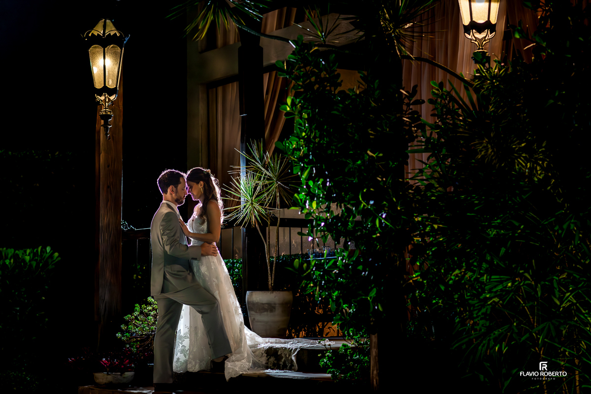 Noivos Laís e Alessandro em ensaio romântico à noite no Villa Lyon de Taubaté, cenário iluminado e sofisticado.