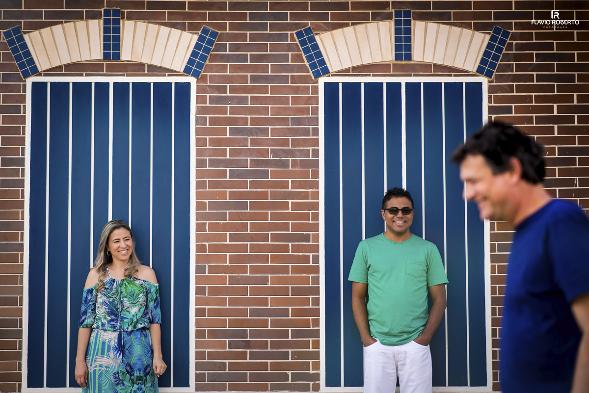 noivos encostados em duas janelas azuis no centro da cidade de Holambra durante Ensaio Pre Wedding 