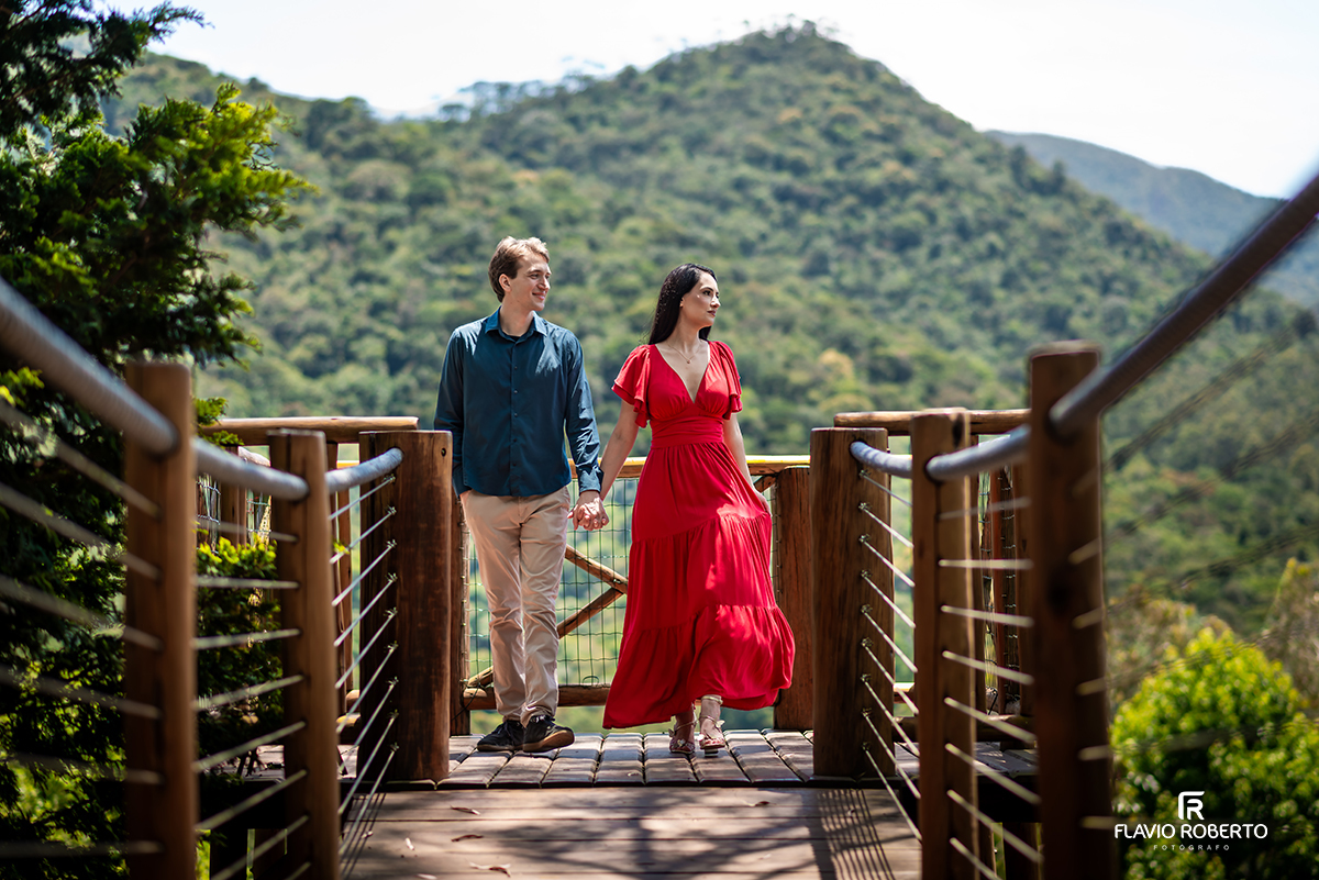 Casal caminhando de mãos dadas na ponte do ensaio pré casamento no Jardim dos Pinhais, Vale do Paraíba.
