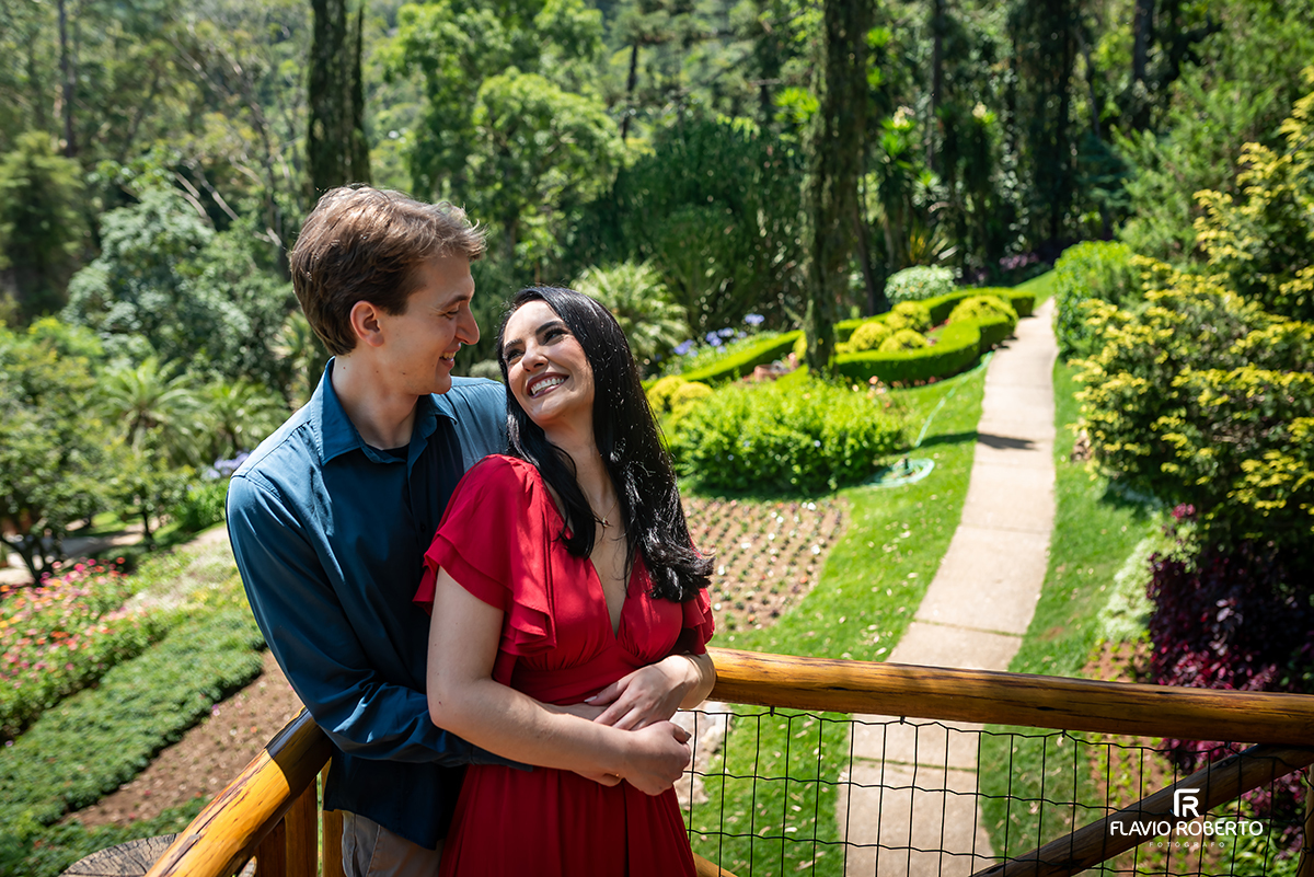 Casal sorrindo em ensaio pré casamento no Jardim dos Pinhais, interior de São Paulo, entre jardins.