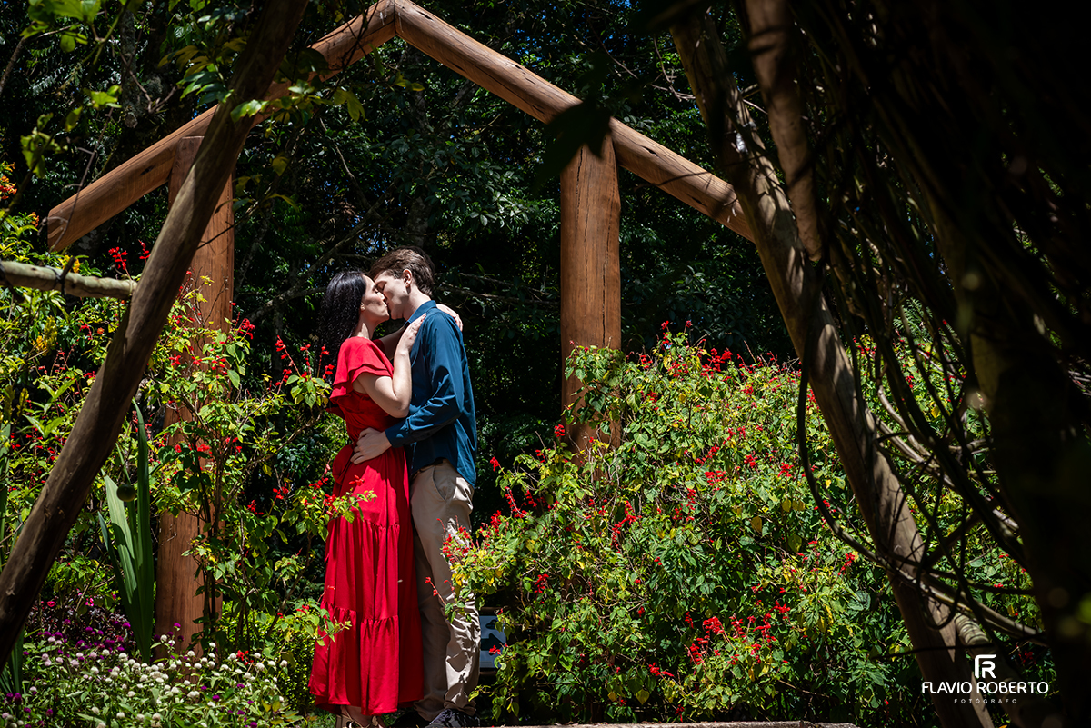 Beijo do casal sob estrutura de madeira no ensaio pré casamento no Jardim dos Pinhais em SP.