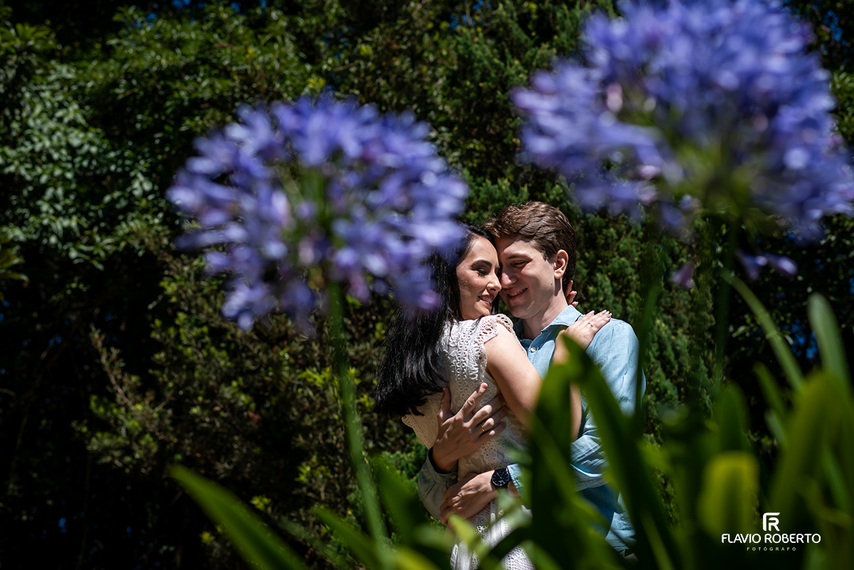 Casal abraçado em meio às flores durante ensaio pré casamento no Jardim dos Pinhais em SP.