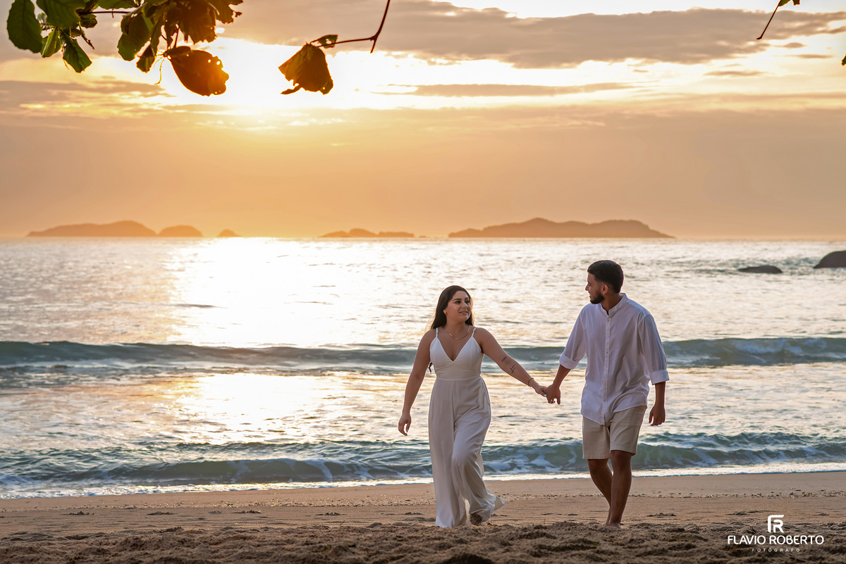 Ensaio pré wedding na praia de Ubatuba com casal caminhando de mãos dadas, fotos naturais e leves no litoral paulista