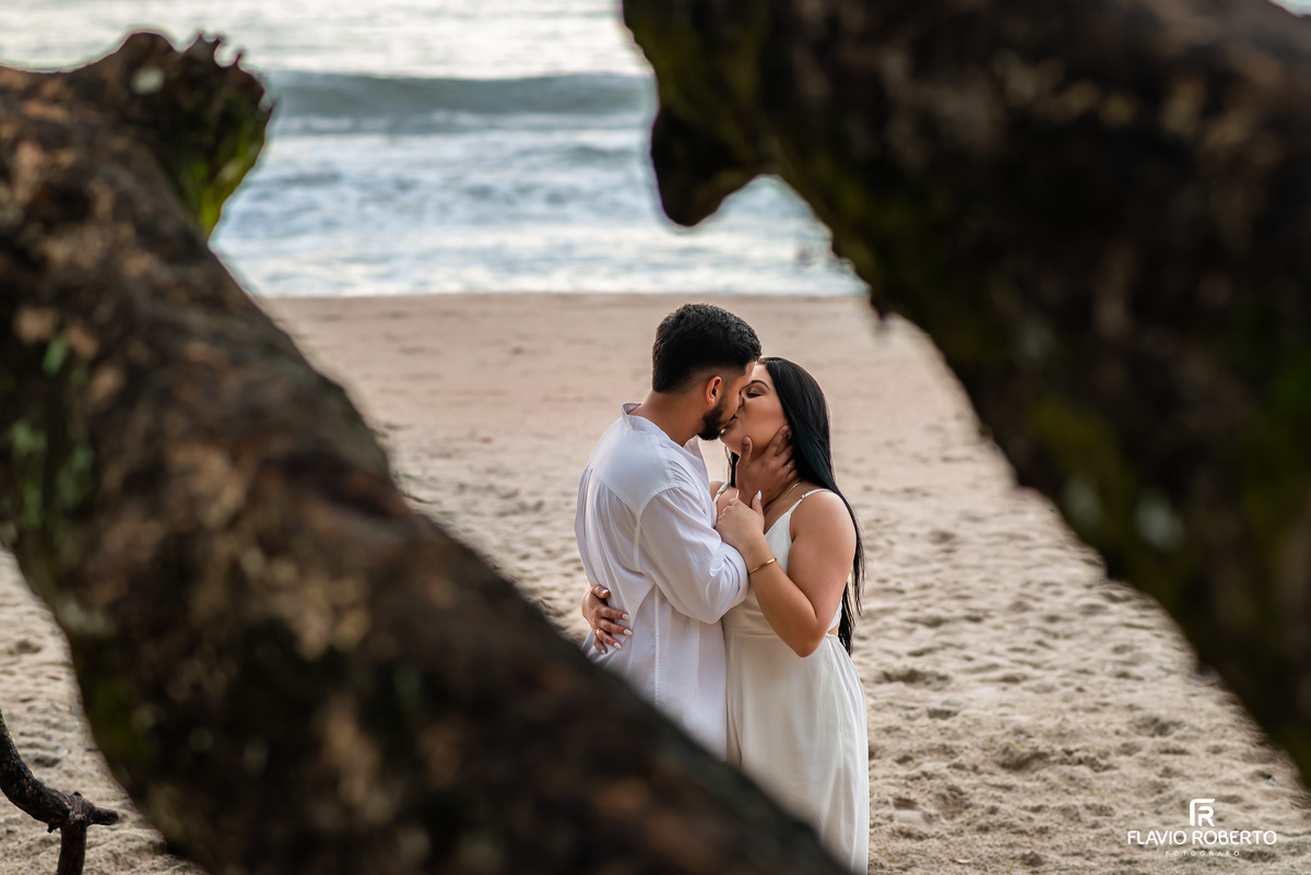 Casal se beijando em ensaio pré casamento na praia de Ubatuba, fotografia natural em meio à natureza
