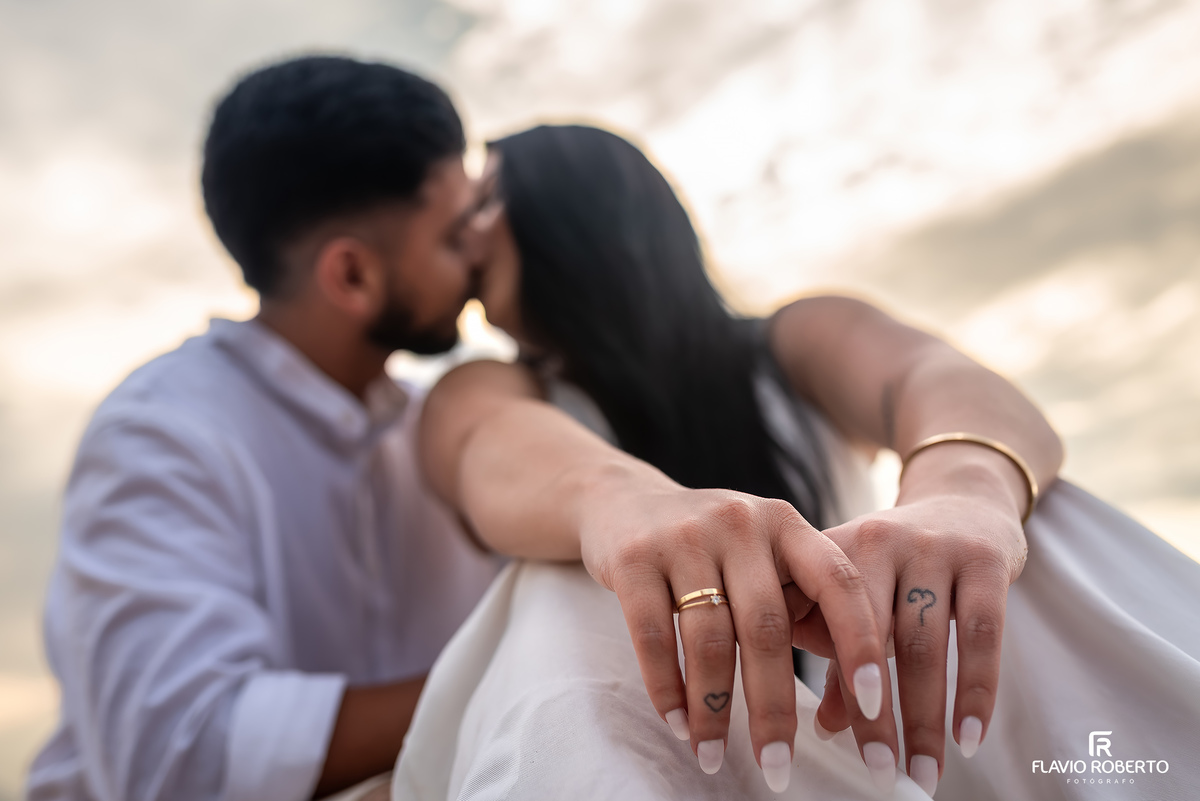 Detalhe de aliança em ensaio pré casamento na praia de Ubatuba ao nascer do sol, fotografia sensível e emocional