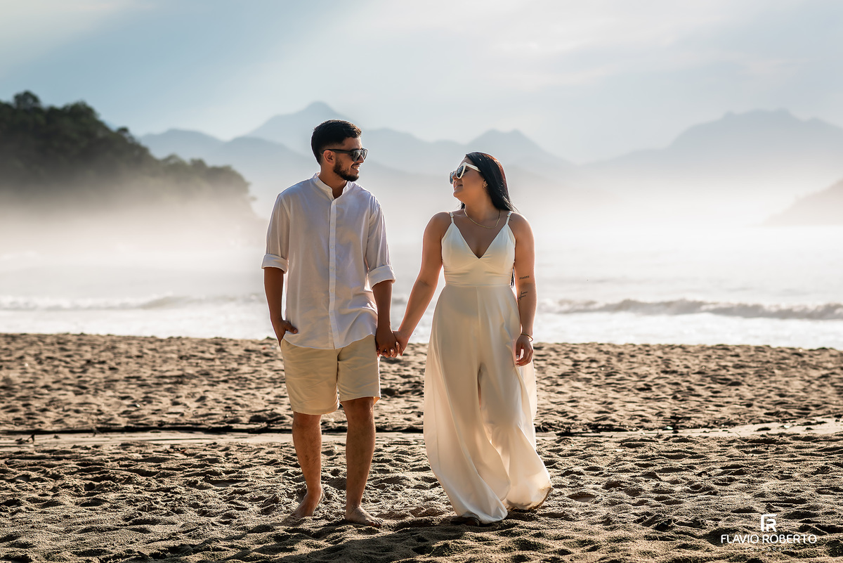 Ensaio pré casamento na praia de Ubatuba ao nascer do sol com casal junto à árvore, fotos românticas e naturais